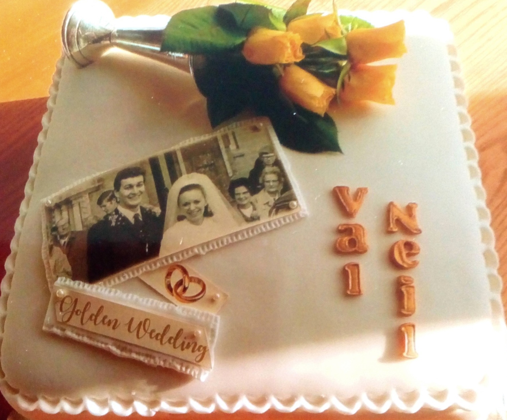 golden wedding anniversary cake with fresh flowers