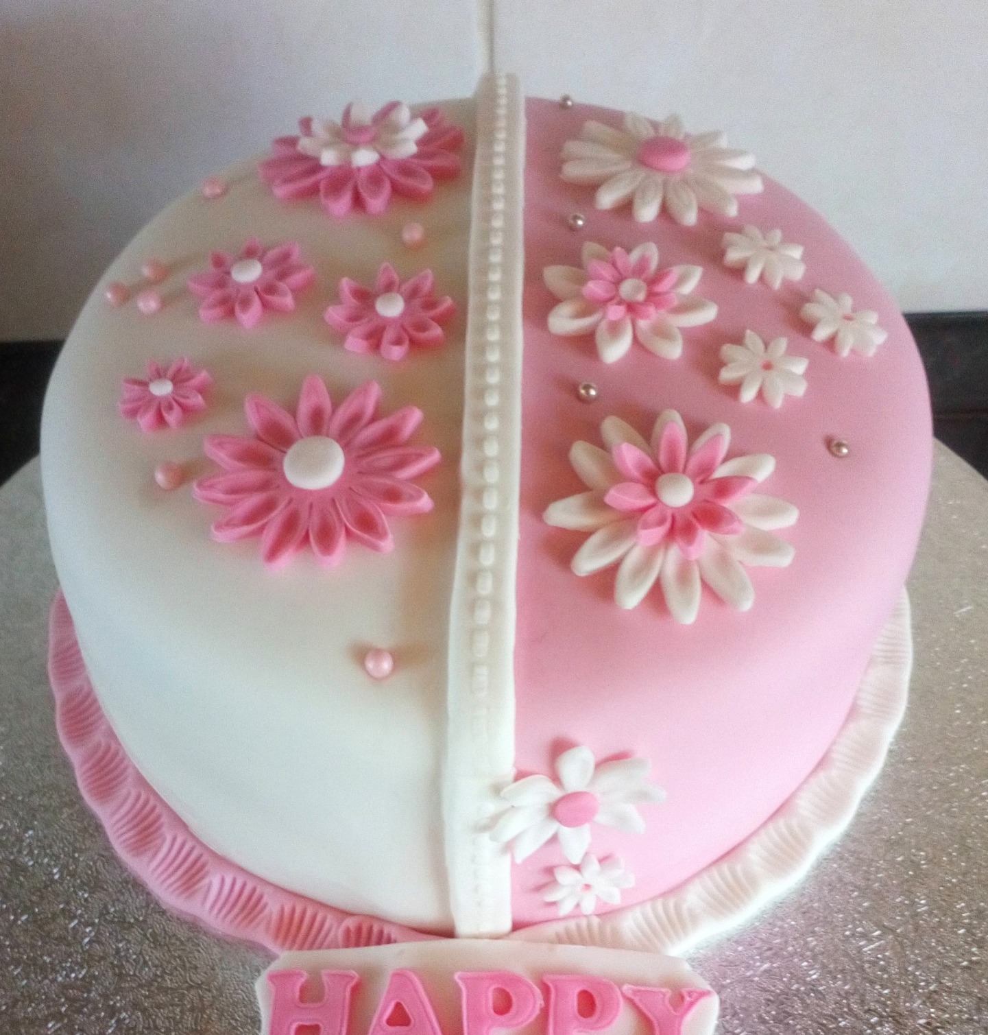 Half pink, half white cake with sugar daisies
