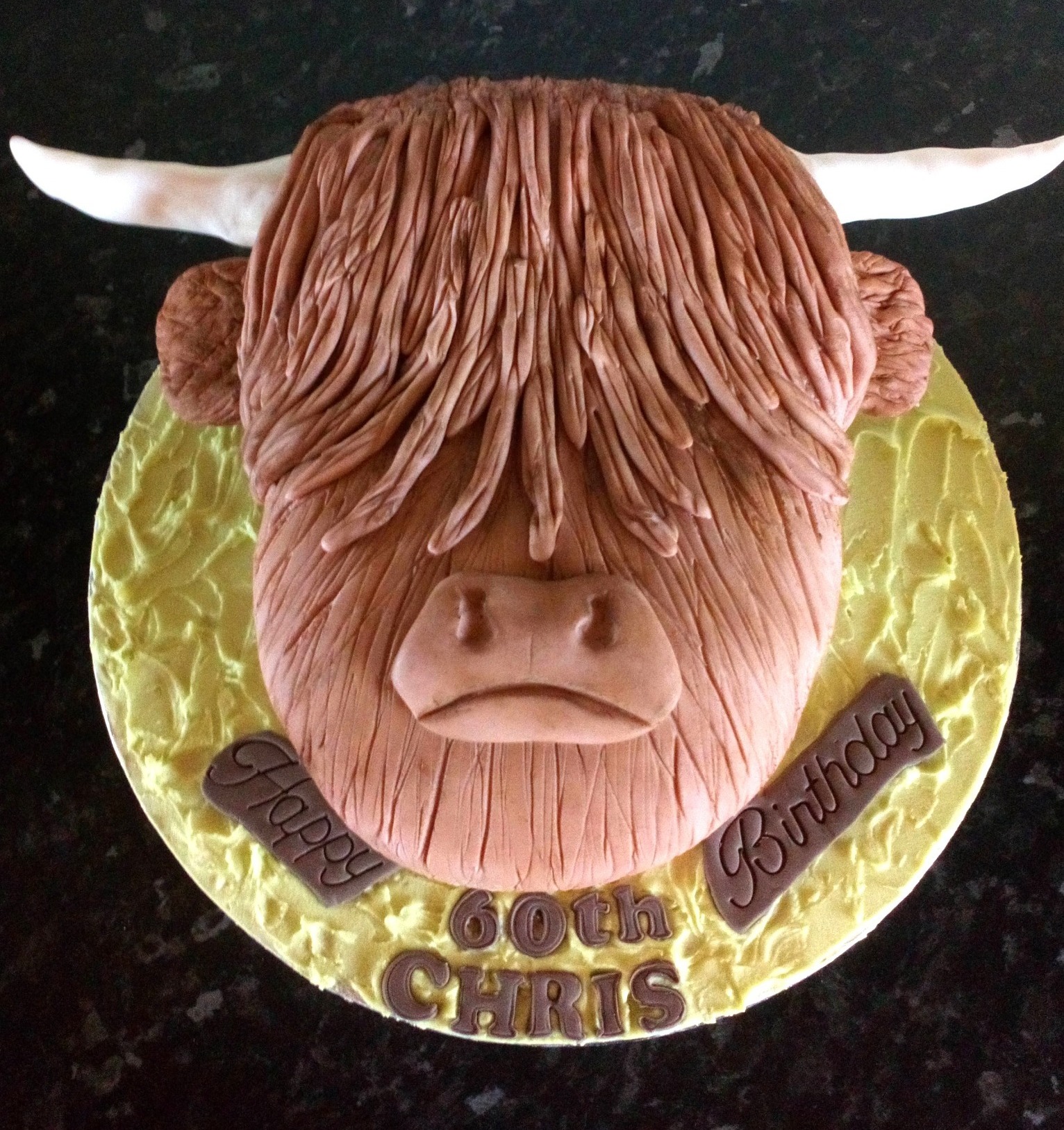 A highland cow novelty cake for a 60th birthday