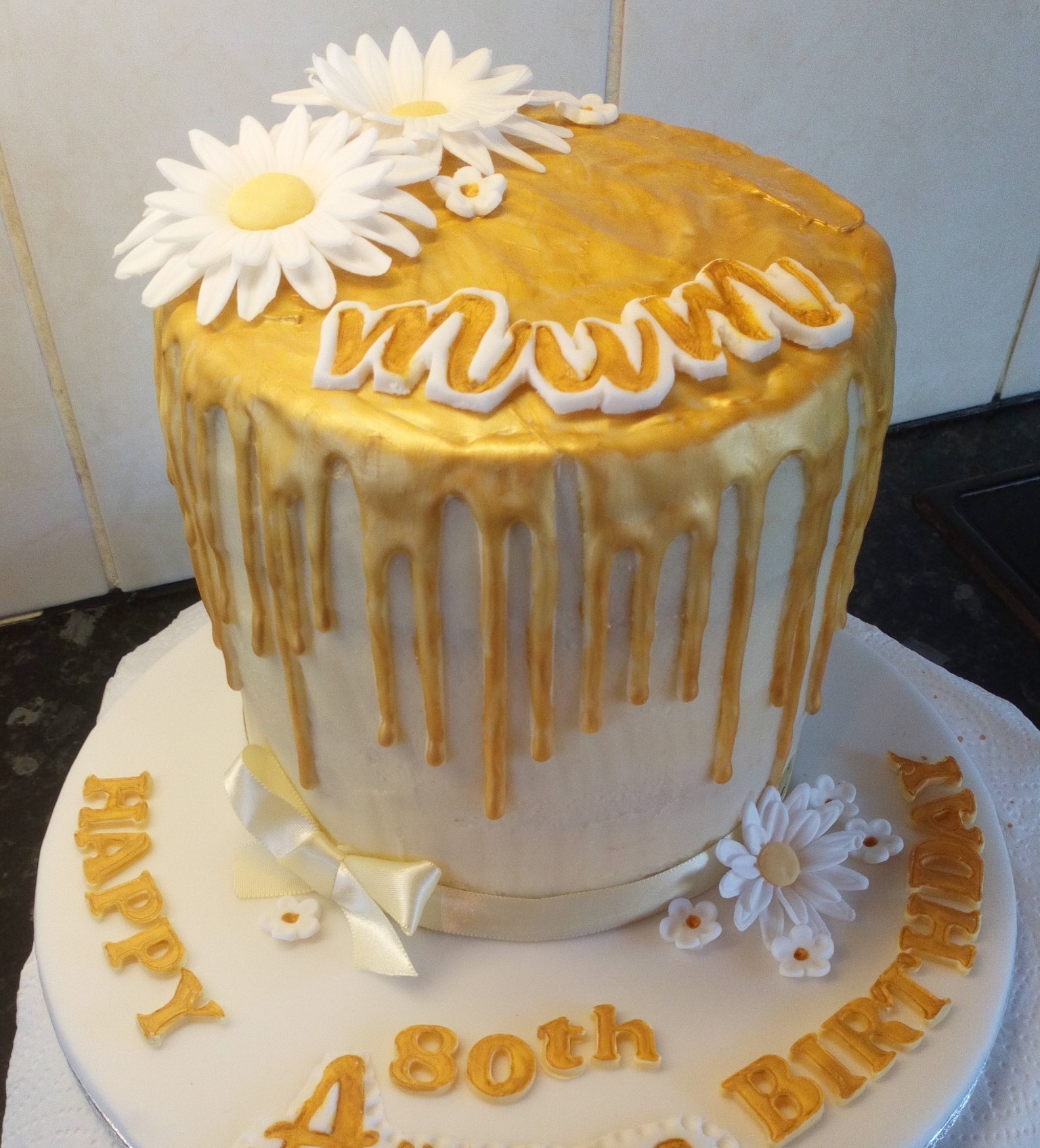 Ladies 80th cake with gold drip and sugar daisies