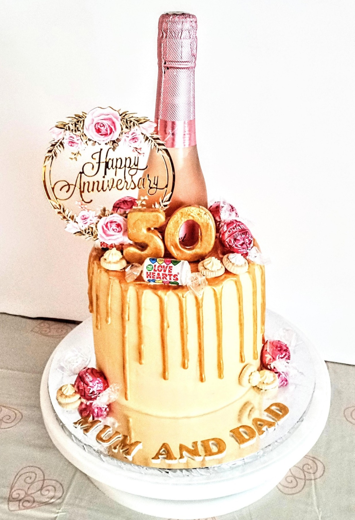 A 50th wedding anniversary rose gold drip cake