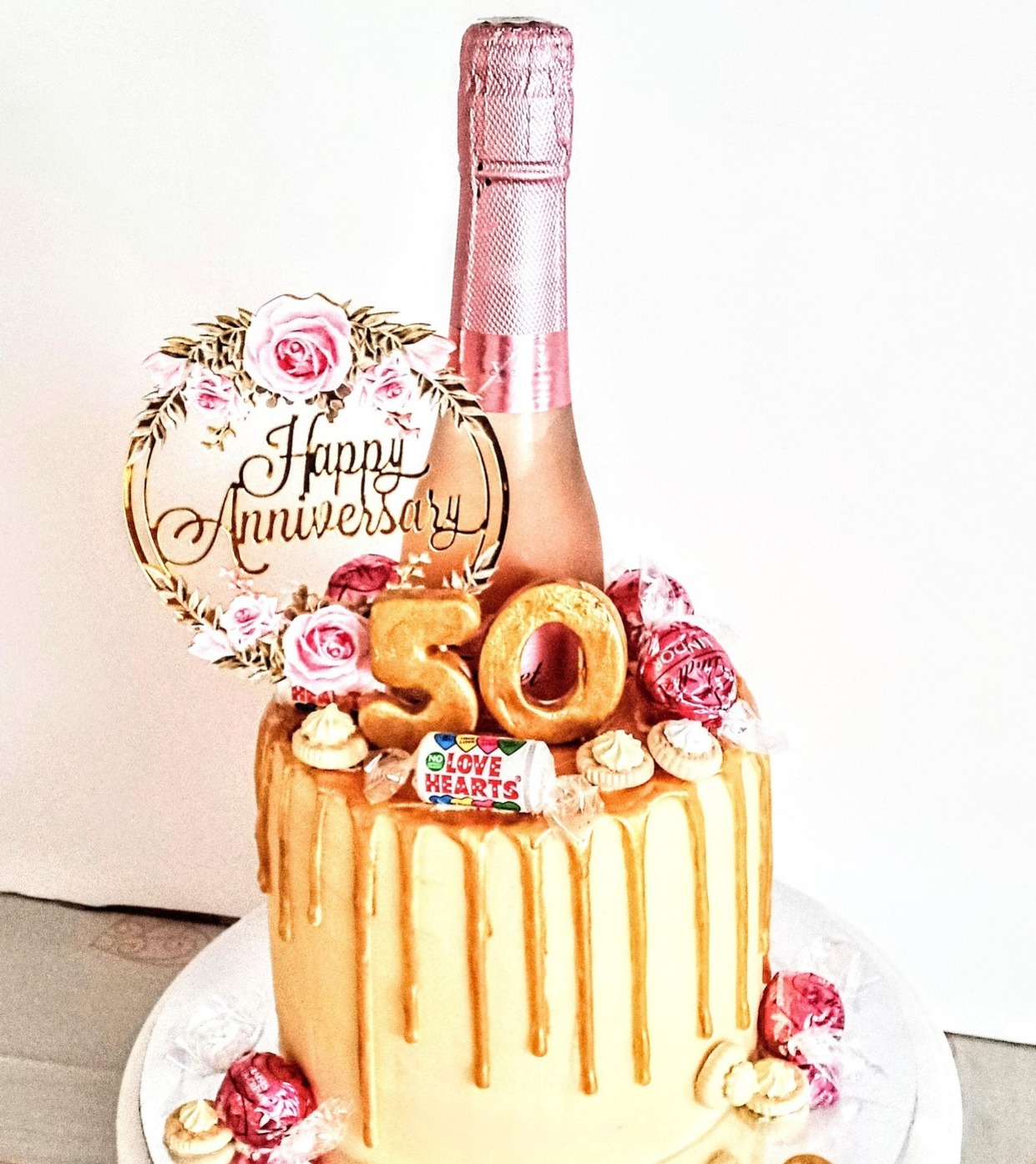 A 50th wedding anniversary rose gold drip cake