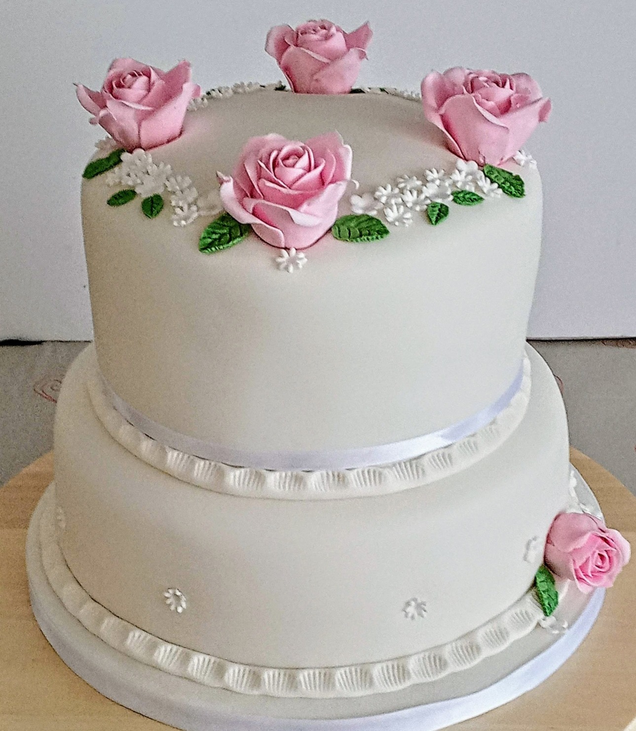 Two tier round wedding cake with large sugar roses