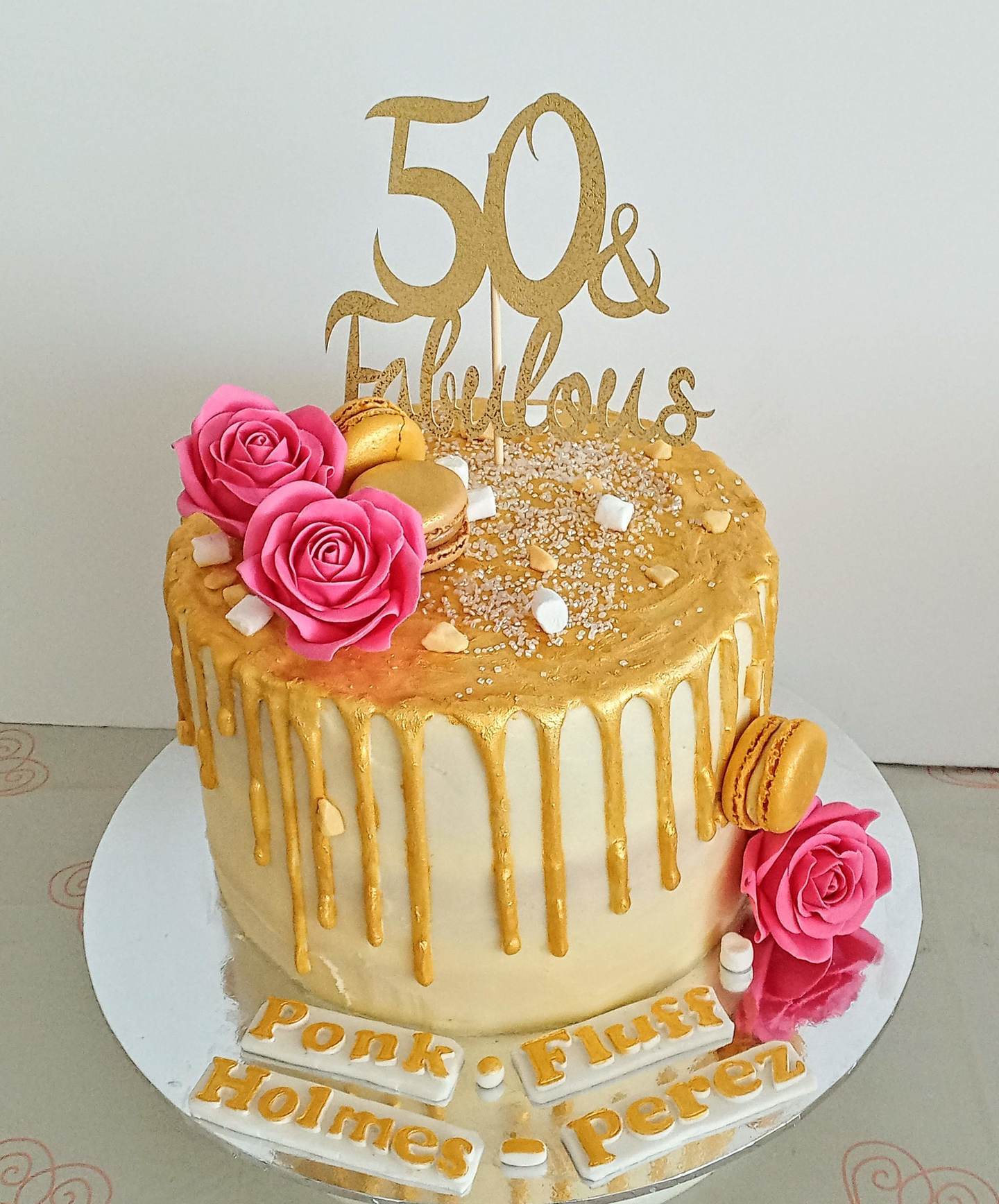 Ladies 50th gold drip cake with pink sugar roses
