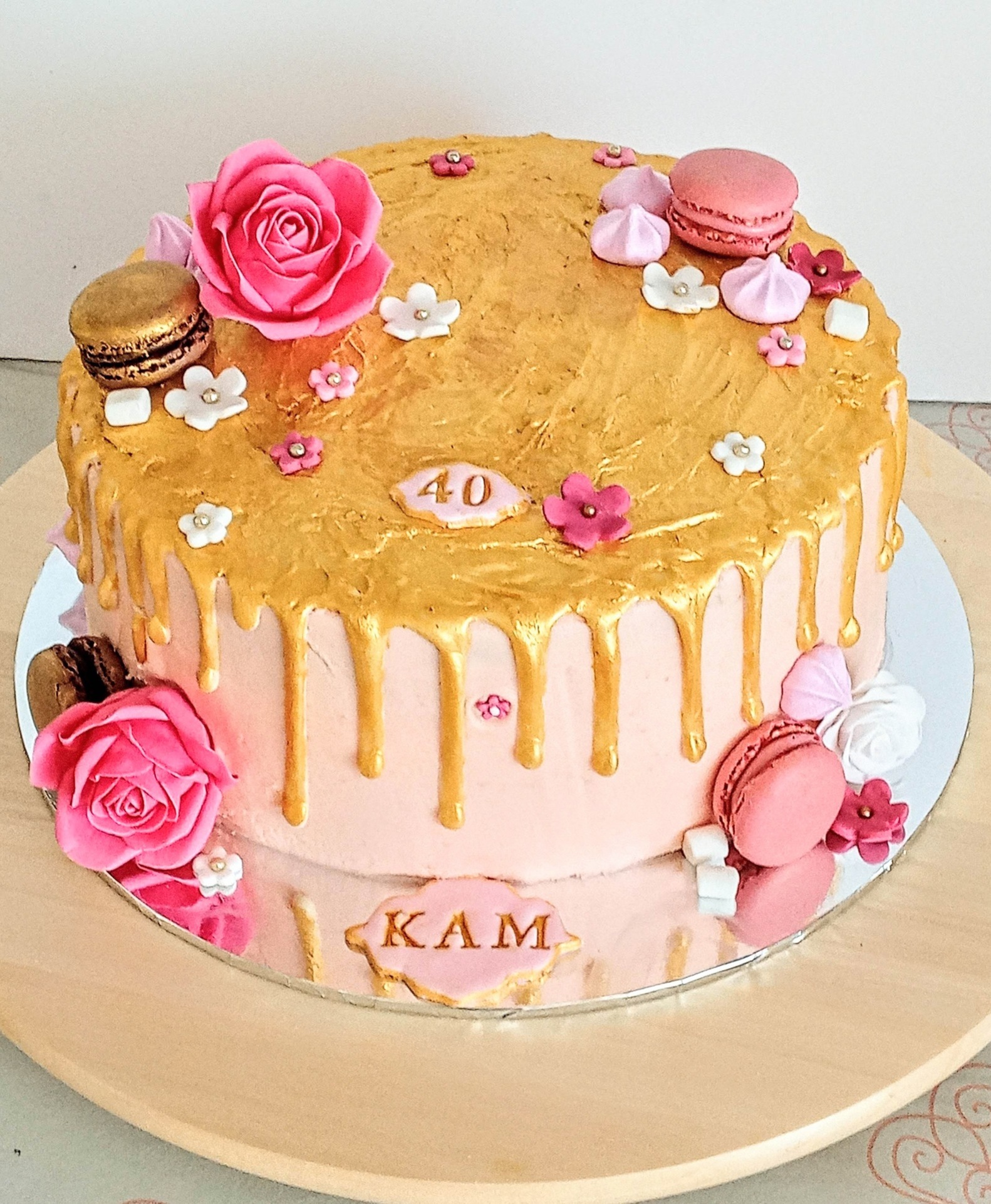 Large ladies 40th gold drip cake with roses and macaroons