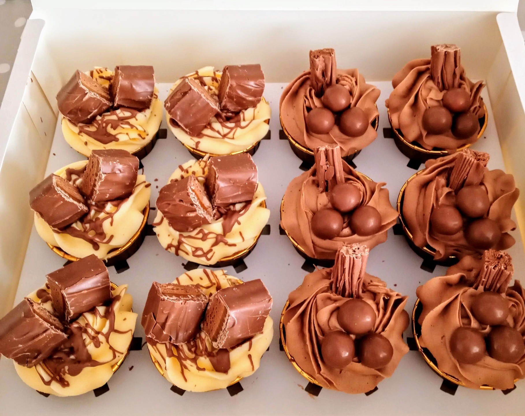 Mixed box of cupcakes topped with chocolate goodies