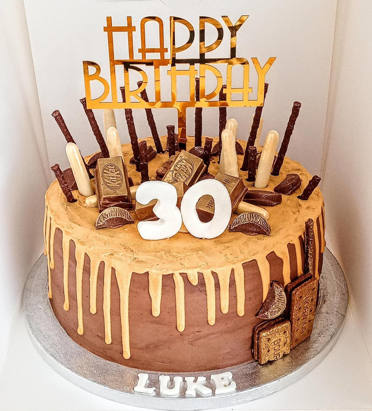 A mens 30th birthday drip cake with chocolates