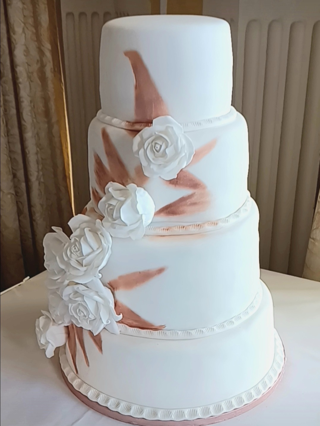 a 4 tier wedding cake with white roses