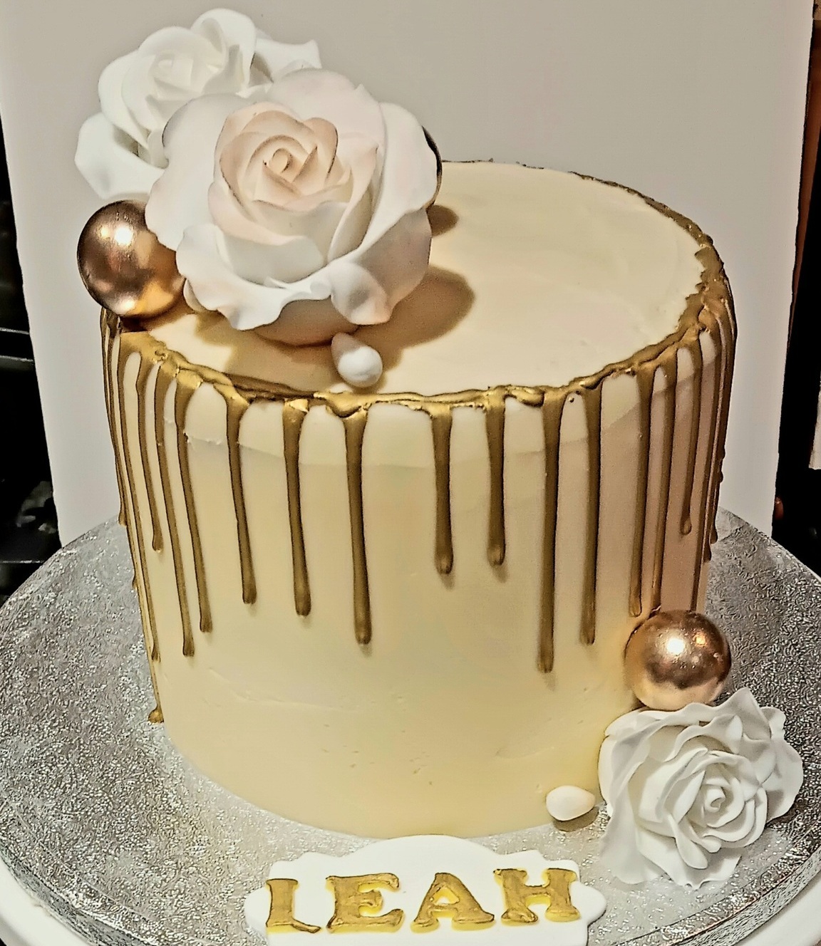 Gold drip cake with handmade sugar roses